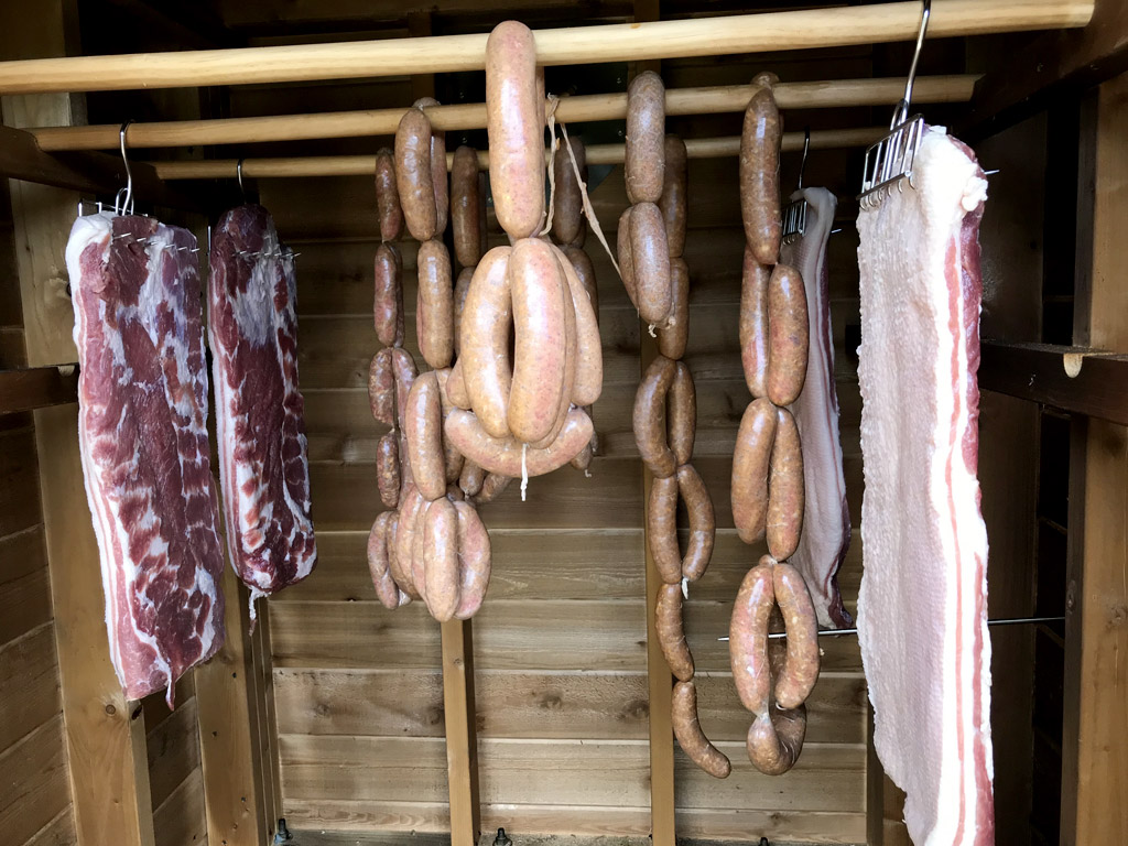 Sausage and bacon hanging in the smoker